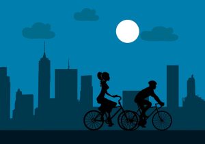 Radfahrende in der Stadt bei Nacht. Mit einer Meldeplattform Radverkehr können Städte und Gemeinden die Sicherheit im Radverkehr erhöhen. Die Bürger haben dann die Möglichkeit, HIndernisse und Schäden per App und Web zu melden.
