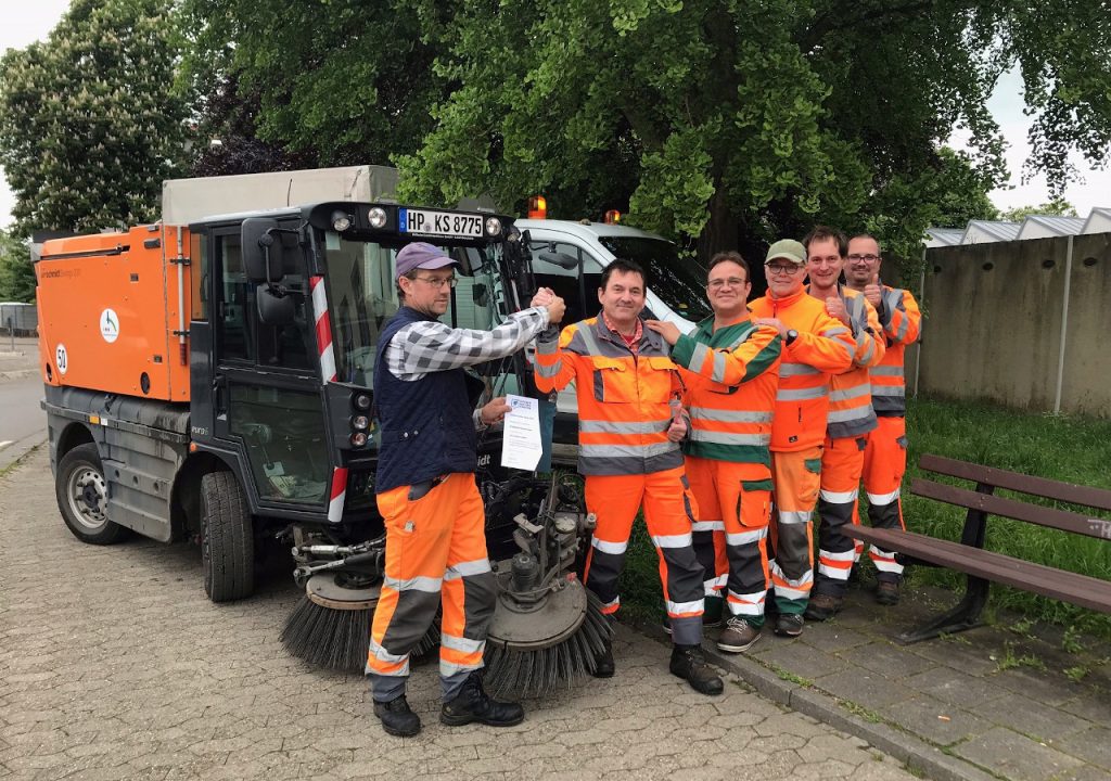 Mitarbeiter des Bauhofs der Stadt Heppenheim vor einer Kehrmaschine. Sie freuen sich über die Auszeichnung der Stadt Heppenheim als 