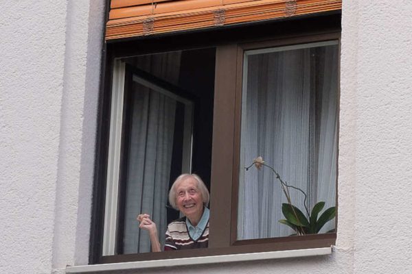 freundliche ältere Dame am Fenster. Die Stadt Friedrichshafen hat die Senior*innen der Stadt zum Wohnen im Alter befragt. Die Umfrage dazu wurde in Zusammenarbeit mit der wer denkt was GmbH durchgeführt.