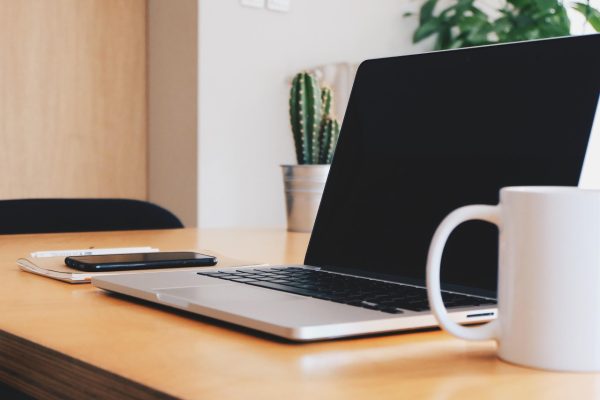 Schreibtisch mit Laptop, Kaffeetasse, Pflanzen. Vom Büro aus kann man ganz flexibel an einem der Online-Termine zur Bürgerbeteiligung teilnehmen