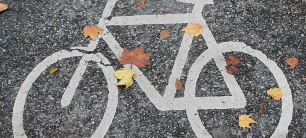 weißes Fahrradsymbol auf grauer Asphaltstraße; Symbolbild zum Newsbeitrag zur Online-Beteiligung der Stadt Graz zur Fahrradstraße in der Laimburggasse