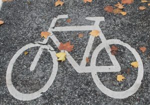 weißes Fahrradsymbol auf grauer Asphaltstraße; Symbolbild zum Newsbeitrag zur Online-Beteiligung der Stadt Graz zur Fahrradstraße in der Laimburggasse