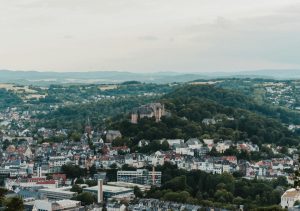 Luftbild von Marburg an der Lahn. Dort findet bis 6. Juli 2025 eine Online-Abstimmung statt, bei der sich die Bürger:innen zum Thema neue Ortsbeiräte in Marburg äußern können.