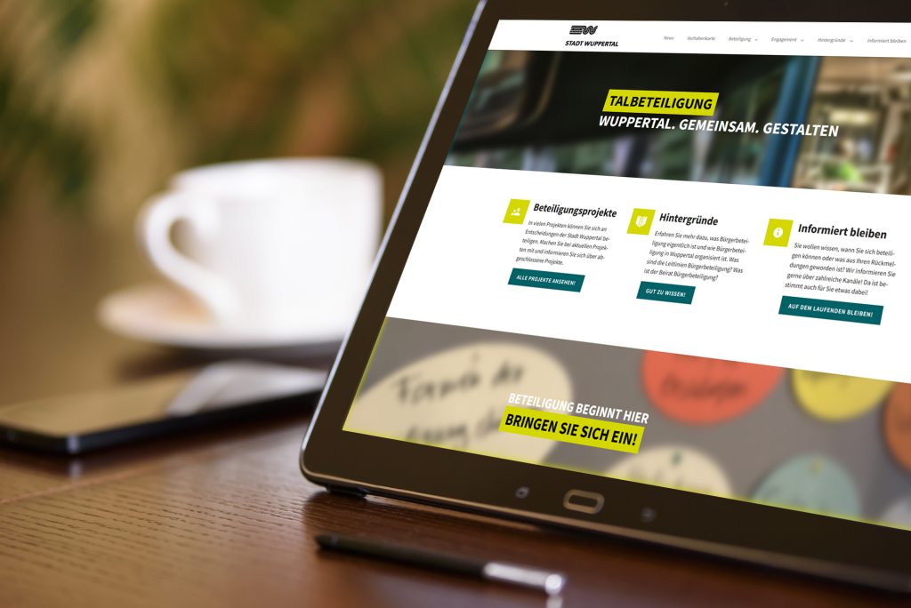 Beteiligungsplattform-Wuppertal-Tablet_c_PhotoMIX-Company_pixabay.com Tablet auf Tisch, daneben ein Smartphone und eine Kaffeetasse. Eine digitale Beteiligungsplattform wie Dialog Digital von wer|denkt|was ist ein effektives und modernes Instrument für den Dialog mit den Bürger:innen. Eine Plattform für Bürgerbeteiligung fördert die Zusammenarbeit zwischen Kommune und Bürgern.